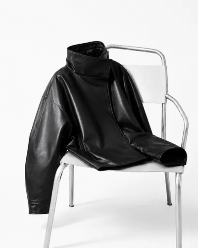 A black leather jacket draped over a steel chair