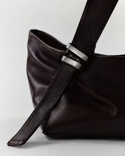 A dark brown leather shoulder bag with a wide strap