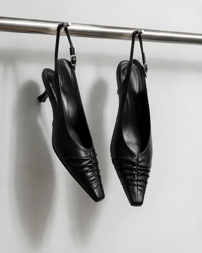 Black slingback heels hanging from a rail